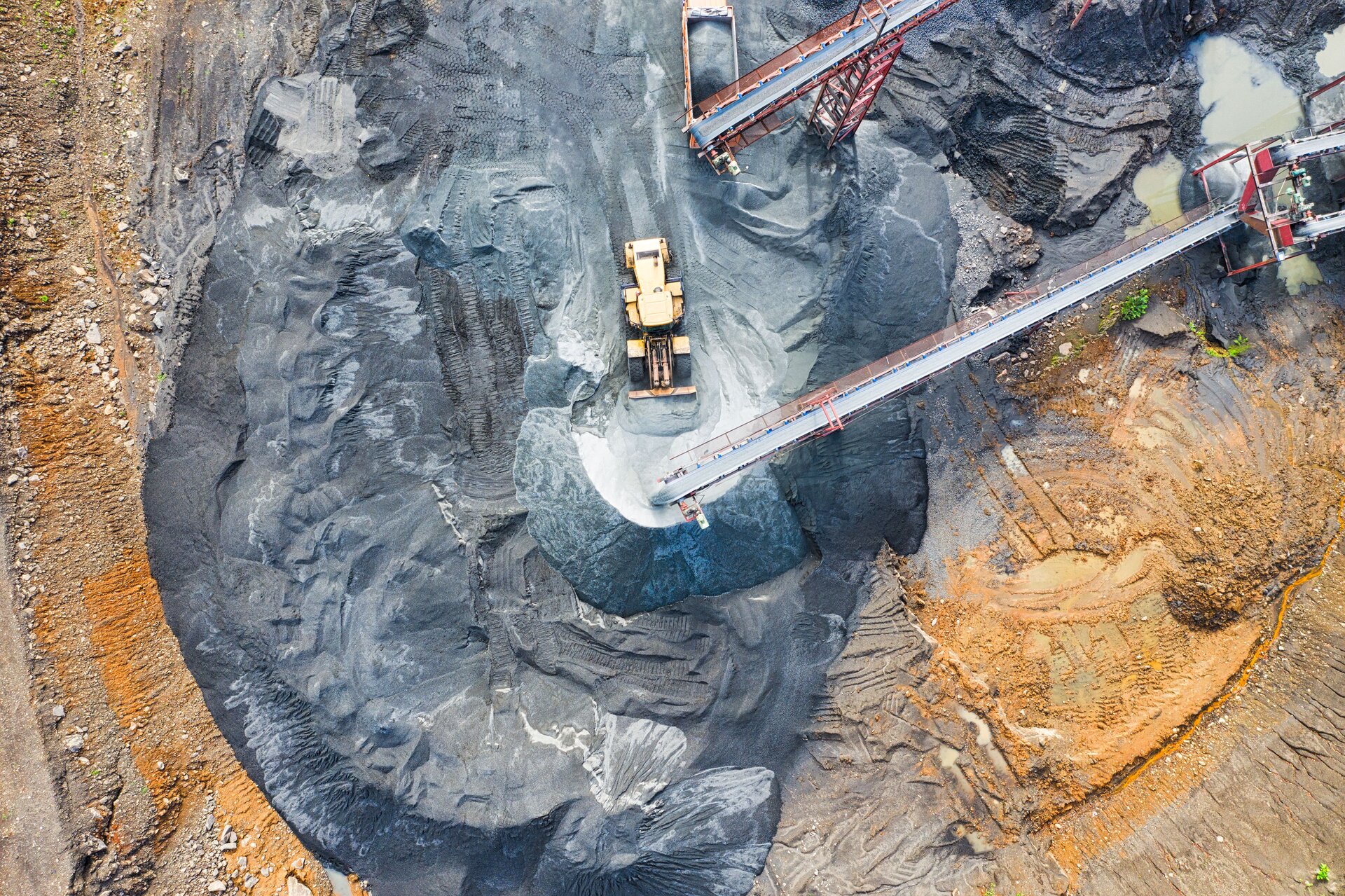 Aerial view of mineral processing facility with aggregate stockpiles and conveyor systems