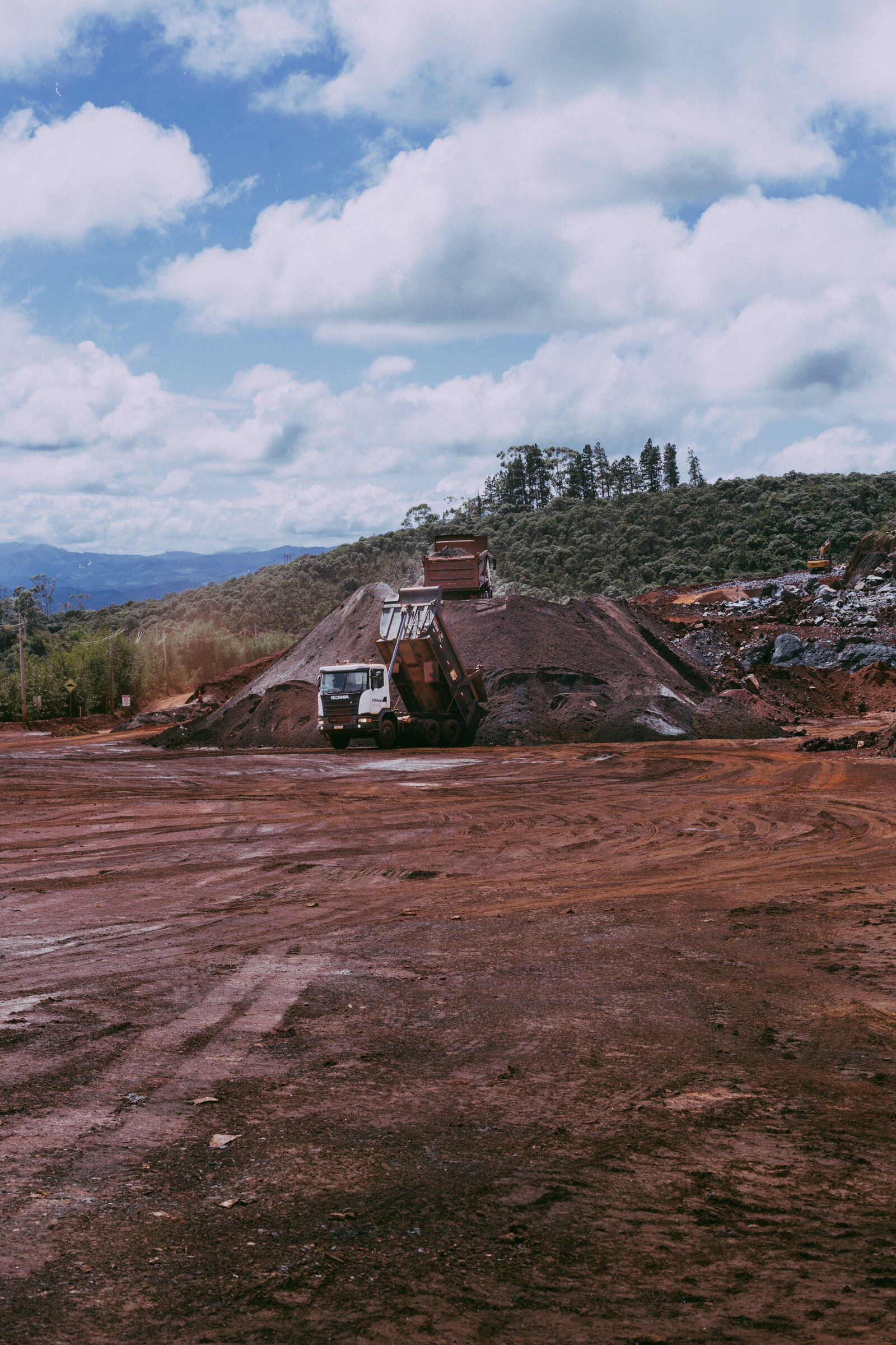 Heavy haulage dump truck depositing mined ore stockpiles